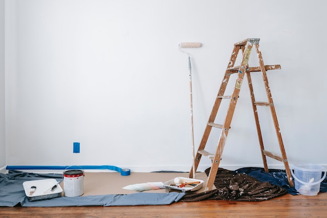 a ladder and paint supplies on top of a blue tarp